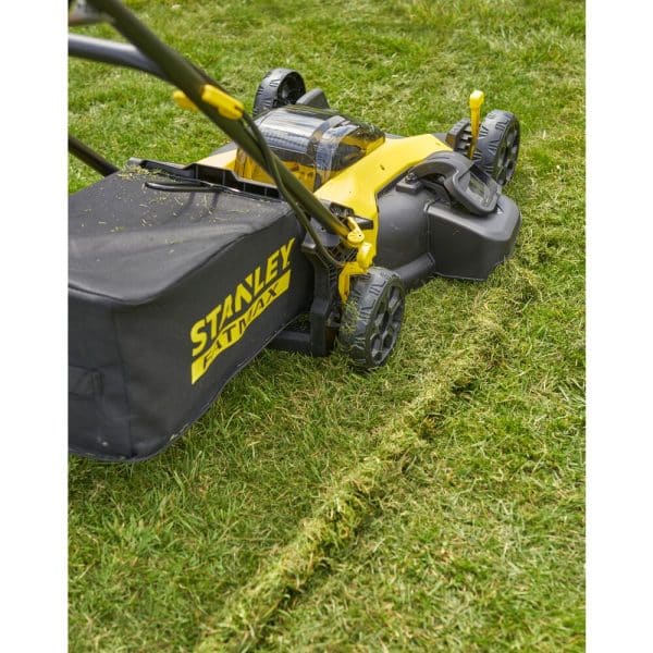 Une tondeuse Stanley Fatmax SFMCMW2651M-QW V20 18V posée sur une pelouse verte et bien entretenue.