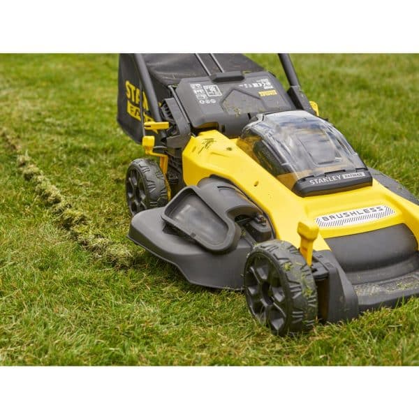 Une tondeuse Stanley Fatmax SFMCMW2651M-QW V20 18V posée sur une pelouse verte et bien entretenue.