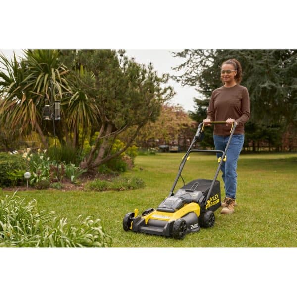 Une tondeuse Stanley Fatmax SFMCMW2651M-QW V20 18V posée sur une pelouse verte et bien entretenue.