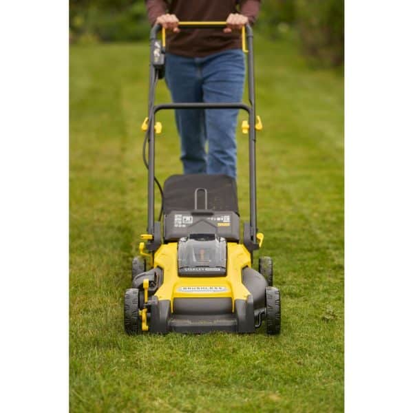 Une tondeuse Stanley Fatmax SFMCMW2651M-QW V20 18V posée sur une pelouse verte et bien entretenue.