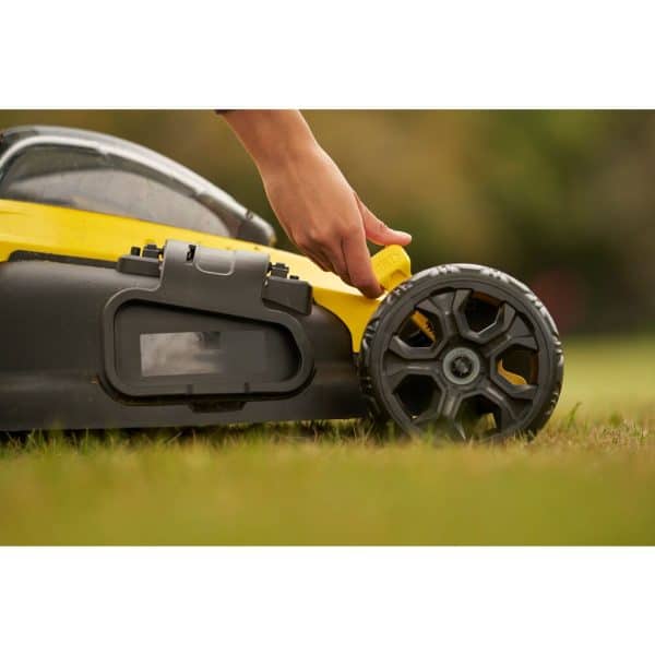 Une tondeuse Stanley Fatmax SFMCMW2651M-QW V20 18V posée sur une pelouse verte et bien entretenue.